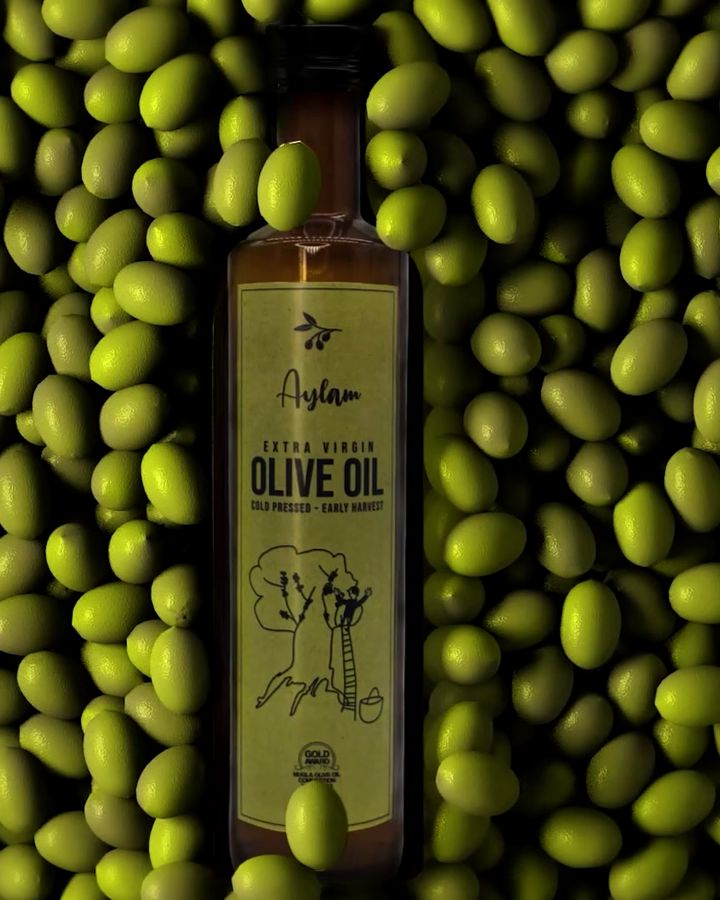 A bottle of Aylam Extra Virgin Olive Oil on a bed of green olives